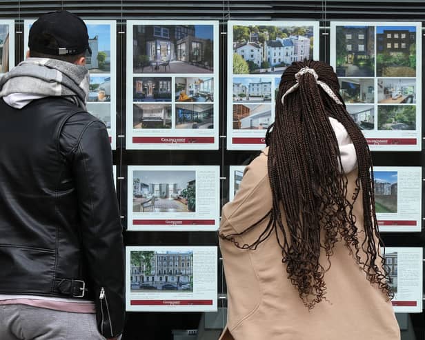 People look at residential properties displayed for sale in the window of an estate agents' in London (Photo: ISABEL INFANTES/AFP via Getty Images)