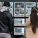 People look at residential properties displayed for sale in the window of an estate agents' in London (Photo: ISABEL INFANTES/AFP via Getty Images)