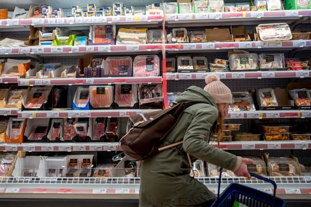 Scanning the shelves from top to bottom to find the cheaper priced items.