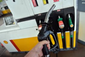 A man poses holding a petrol pump nozzle at a filling station in Birkenhead, north-west England.  (Photo credit should read PAUL ELLIS/AFP via Getty Images)