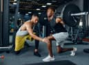 Man with his trainer in gym (Adobe)