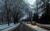 Cars drive on snowy roads in Liverpool.