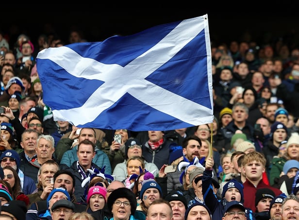 <p>A Scotland fan waves a national flag as they enjoy the pre-match atmosphere prior to a Six Nations Rugby match at Murrayfield Stadium</p>