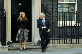 Prime Minister Boris Johnson and his partner Carrie Symonds stand outside the door of number 10 Downing Street (Photo by Leon Neal/Getty Images)