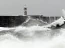 Waves crash over the breakwater by Newhaven Lighthouse as Storm Barra passes through Newhaven, southern England on December 7, 2021. (Photo by GLYN KIRK / AFP) (Photo by GLYN KIRK/AFP via Getty Images)