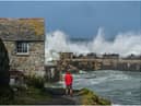 National Trust ranger Seth Jackson looks on as large waves caused by Storm Ellen strike Cornwall in 2020 (Photo by Hugh R Hastings/Getty Images)