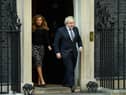 Prime Minister Boris Johnson and his partner Carrie Symonds stand outside the door of number 10 Downing Street (Photo by Leon Neal/Getty Images)