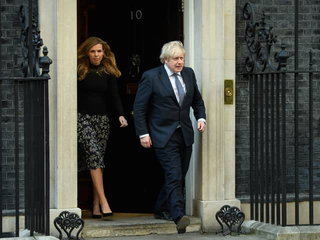 Prime Minister Boris Johnson and his partner Carrie Symonds stand outside the door of number 10 Downing Street (Photo by Leon Neal/Getty Images)