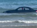 A convertable BMW was washed out to see after parking on a beach in Cornwall