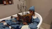 Depop entrepreneur Callum Massey poses in a bath full of deadstock nike beanies from 2002 that he purchased and resold on the site. 