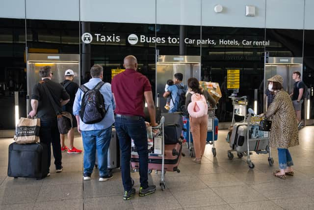 People queue for a lift at Heathrow Airport.