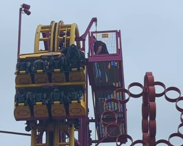 Horrified onlookers watched as rescuers scrambled to the aid of eight terrified people stuck “at the top” of a 22-metre rollercoaster.