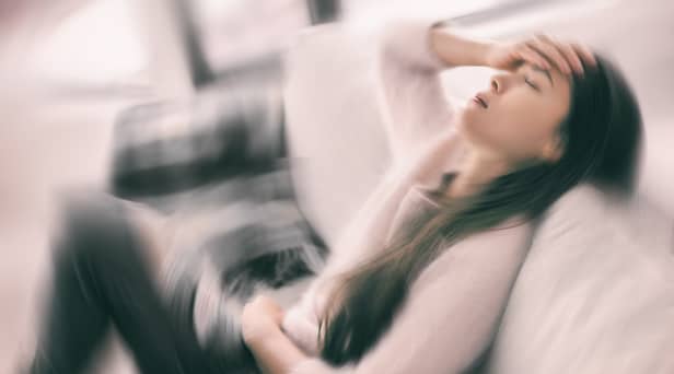Stock image of woman holding her head in pain