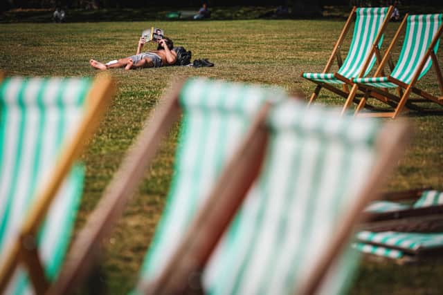 A man reads a book while sunbathing in Green Park in central London on September 5, 2023 as the country experiences a late heatwave. 