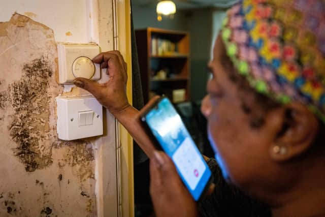 Doreen Thompson adjusts her thermostat at her home as she limits her use of heating to keep up with her increasing energy bills, at her home in south London.