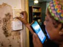 Doreen Thompson adjusts her thermostat at her home as she limits her use of heating to keep up with her increasing energy bills, at her home in south London.