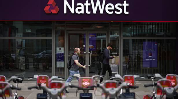 Pedestrians walk past a branch of a NatWest bank in London.