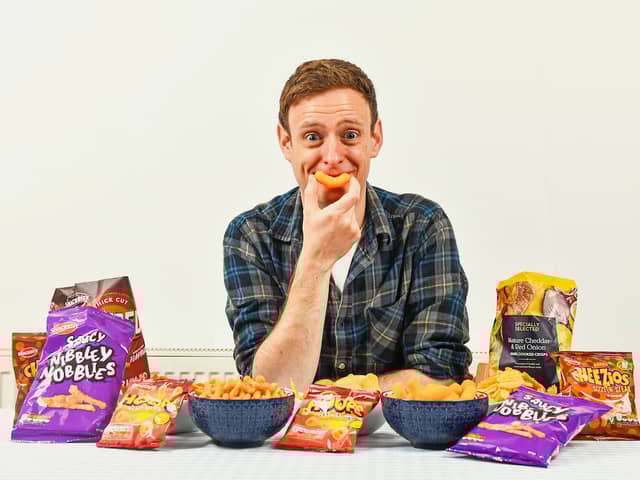 Aldi Chief Crisp Tasting Officer George Critchley with a range of Aldi own brand crisps. (Photo: PR Handout)
