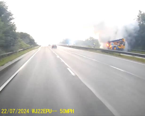 Fire rages through crane on A road as smoke billows into air.