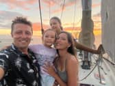 Dan Monk, his wife Bow, and their children Amelia and Olivia sailing on their yacht, Pancakes.