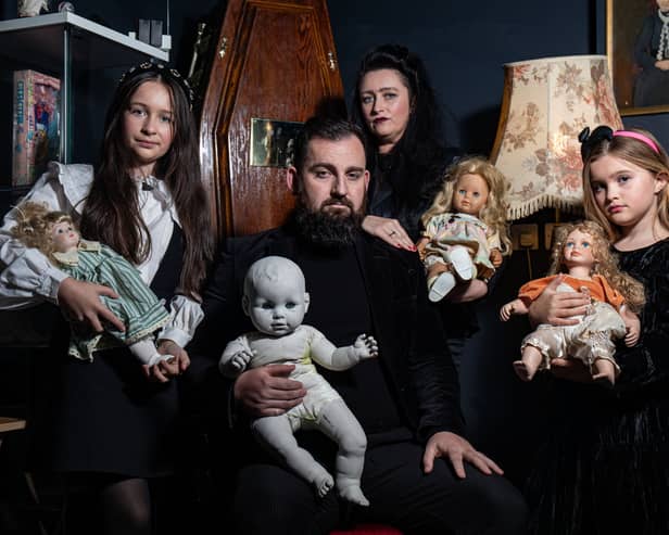 JP Kennedy and Kymmi Jeffery with daughters Snow and Pebble (L-R), known as The Occult Family, holding haunted dolls inside their haunted room.