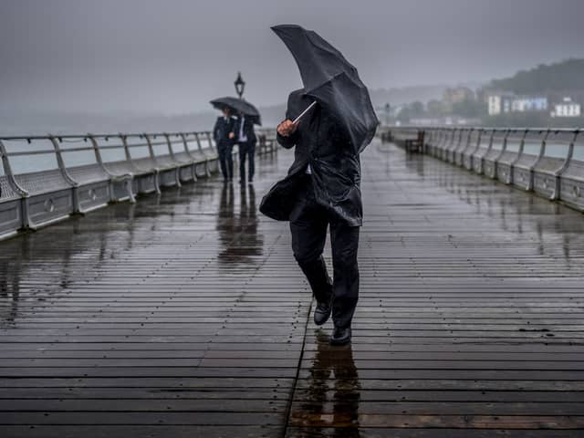 People battle against the wind and rain.