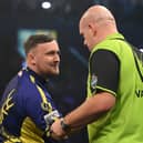 Luke Littler congratulates Michael van Gerwen on his victory during the opening night of the Premier League Darts season at The SSE Arena Belfast