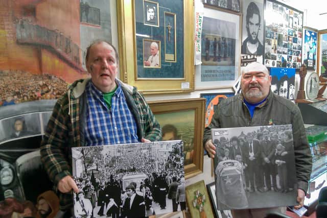 Tony O’Hara and  Danny Morrison with photographic exhibitions from the funerals of local men who died on Hunger Striker, with the Papal cross in the background