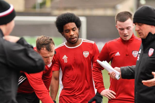 Derry City forward, Walter Figueira listens to instructions from Derry boss, Declan Devine during training at Brandywell