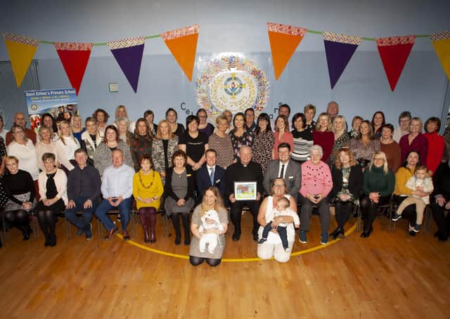 The Bishop of Derry, Dr. Donal McKeown pictured with Mr. Terence McDowell, Principal, staff. board of governors and friends after Fridayâ€TMs 20th Anniverary Mass at Holy Family Church, Ballymagroarty.