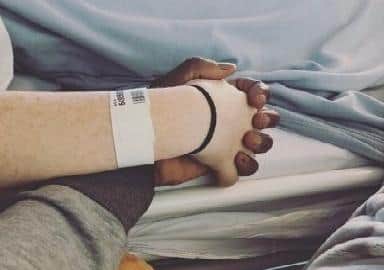 Melissa and Terry hold hands in hospital.