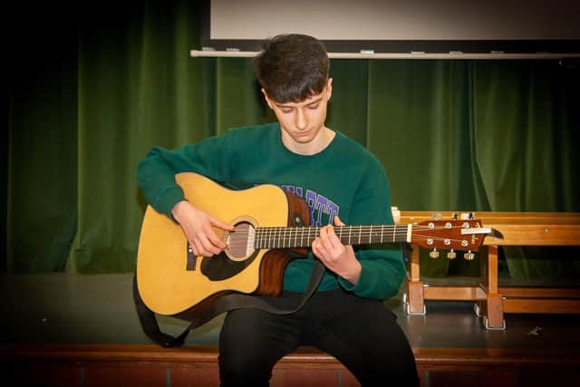 Young Rory on guitar entertains the audience at Friday nightâ€TMs †̃Letâ€TMs Talkâ€TM Cultural Diversity celebration.