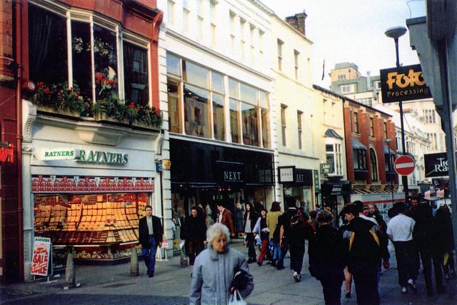 Commercial Street, showing, from left,Ratners Jewellers with Bistro Fiori restaurant above, then Next fashions, Monsoon ladieswear and Julian Jay hairdressers then a vacant shop. On the right are Foto Processing and Tie Rack.