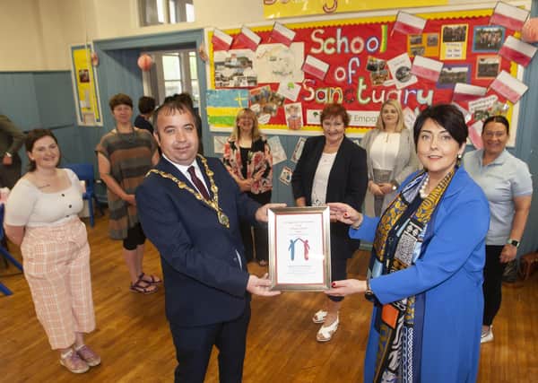 The Mayor, Councillor Brian Tierney presents the â€ ̃School of Sanctuaryâ€TM award to St. Eugeneâ€TMs Principal Ms. Teresa Duffy on Friday. At back from left are ????????, Bogside Brandywell Health Initiative, Margarite McNamee, BOG, Mary Delargy BOG, Sue Nelis BOG, Aisling Leonard BOG, and Lorraine Kivelhan, Bogside and Brandywell Health Initiative.