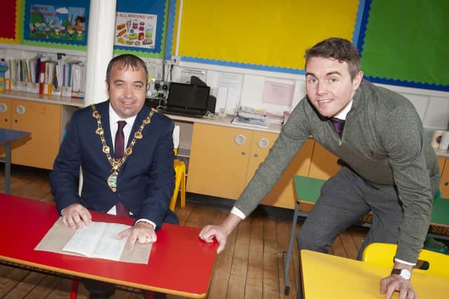 REGISTRATION. . . . Mayor, Councillor Brian Tierney checks his P1 register under the guidance of teacher Mr. Joe Kennedy, also a former pupil at St. Eugeneâ€TMs PS during Fridayâ€TMs Mayoral Visit. (Photos: Jim McCafferty Photography)