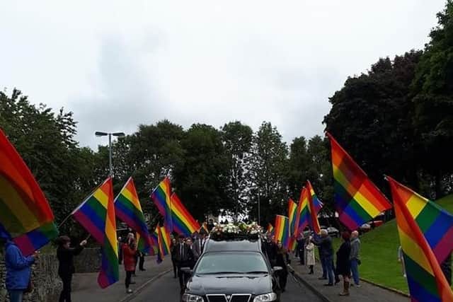 Friends line the route with Rainbow flags in honour of Susannah Toland as her funeral cortege passes Hogg's Folly on Tuesday. (Picture courtesy of Sha Gillespie)
