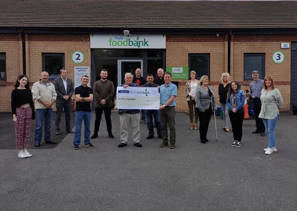 ABOVE: Artists and performers from the Magnificent Seven crew handing over the cheque for £10,000 to staff from the Foyle Foodbank.