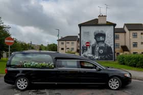 The funeral cortege of Patrick (Paddy) Coyle passes the Gasmask mural in the Bogside on its way to the City Cemetery after Requiem Mass in St Eugene’s Cathedral. Photo: George Sweeney DER2030GS – 001