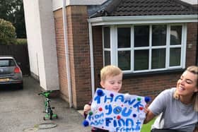 Finn shows the cyclists the poster he made for them as he supports them on their 16,000km challenge for his school, Ardnashee.