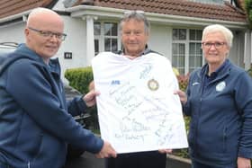 The missing ink...Jim 'Chang' Smith (centre) displayed the fully autographed Finn Harps 1974 FAI Cup winning replica jersey which goes on raffle this week with from left, Gerard McHugh and Harps shop staff member, Ann Kelly. Jim was the last name to be added to the jersey.