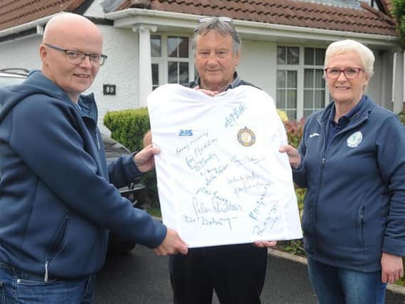 The missing ink...Jim 'Chang' Smith (centre) displayed the fully autographed Finn Harps 1974 FAI Cup winning replica jersey which goes on raffle this week with from left, Gerard McHugh and Harps shop staff member, Ann Kelly. Jim was the last name to be added to the jersey.