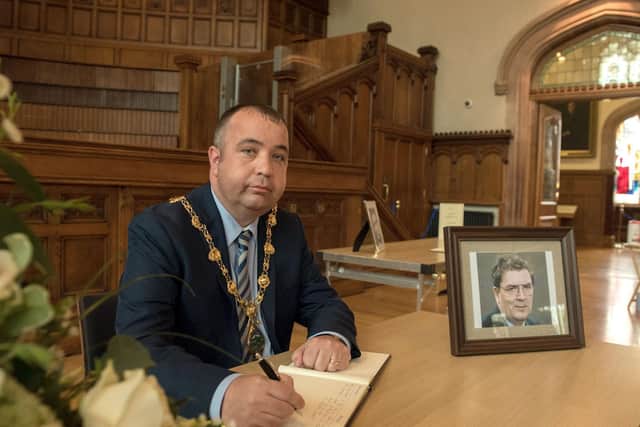 The Mayor of Derry and Strabane, Councillor Brian Tierney, signs a Book of Condolence in memory of John Hume.