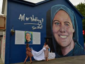 Shauna Gill, on the left, and Megan Nicell unveil  a prayer card at the a mural dedicated to the  memory of their sister Sr. Clare Crockett , on Sunday evening last. DER2034GS - 008