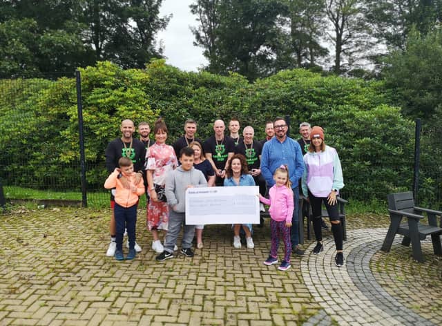 Children and staff from Ardnashee School and College and members of the PTA are presented with a cheque for £15,000 by a group of cyclists who cycled over 16,000km.