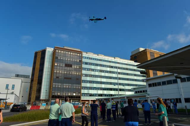 Staff look on as the THANK U NHS Spitfire flies over Altnagelvin Hospital on Thursday afternoon. DER2038GS – 049