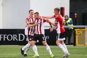 Derry City's Ciaran Coll (left) and Ciaron Harkin celebrate with midfielder Conor Clifford (middle) after his Panenka-style penalty finish.
