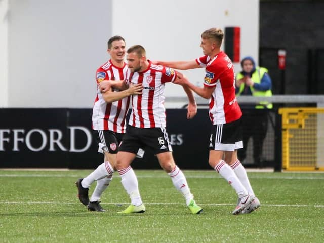 Derry City's Ciaran Coll (left) and Ciaron Harkin celebrate with midfielder Conor Clifford (middle) after his Panenka-style penalty finish.