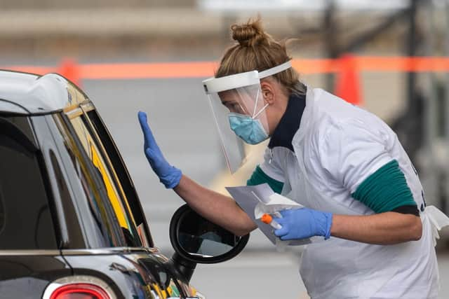 Staff collect samples at a drive through test centre.