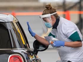 Staff collect samples at a drive through test centre.