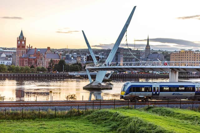The train from Belfast passes the Peace Bridge as it arrives in Derry.